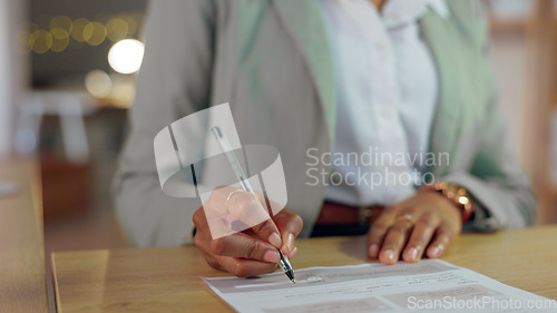 Image of Woman, hands and writing signature for business contract, application or form with pen at night on office desk. Closeup of female person filling documents or signing paperwork for legal agreement