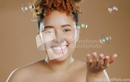 Image of Portrait, skincare and woman with bubbles in studio for beauty in mockup with brown background. Person, model and smile with satisfaction for wellness with treatment, smooth and glow of face