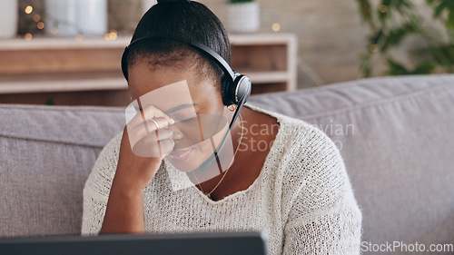 Image of Stress, customer support and remote work with a black woman consultant on a sofa in the living room of her home. Depression, headache and an unhappy employee problem solving for help or assistance