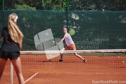 Image of Young girls in a lively tennis match on a sunny day, demonstrating their skills and enthusiasm on a modern tennis court.