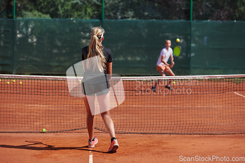 Image of Young girls in a lively tennis match on a sunny day, demonstrating their skills and enthusiasm on a modern tennis court.