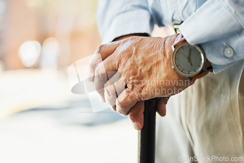 Image of Senior, hands and stand with cane in closeup for retirement, vacation or trip on blurred background. Elderly, person and wrinkles with health, medical care or wellness in rehabilitation for injury