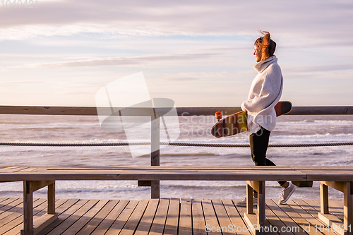 Image of Girl holding a skateboard 