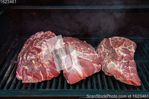 Image of Beef steaks on the grill with flames