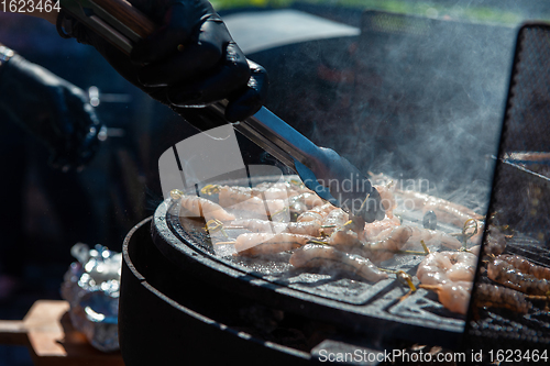 Image of A professional cook prepares shrimps