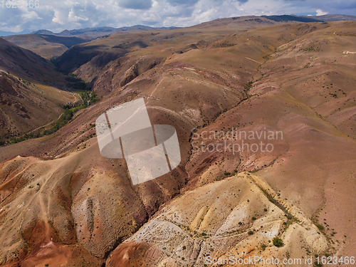 Image of Aerial shot of the textured yellow nad red mountains resembling the surface of Mars