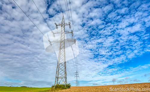 Image of High voltage power lines against a blue sky