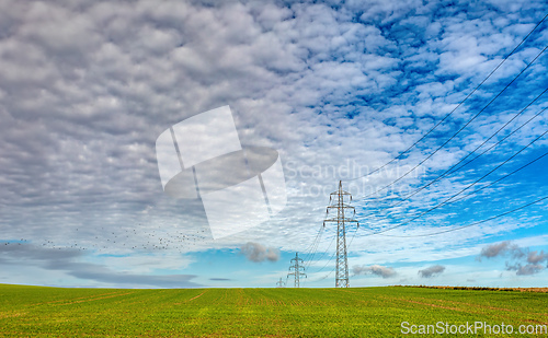 Image of High voltage power lines against a blue sky