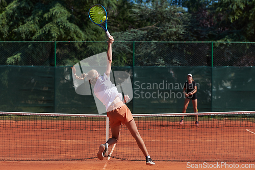 Image of Young girls in a lively tennis match on a sunny day, demonstrating their skills and enthusiasm on a modern tennis court.