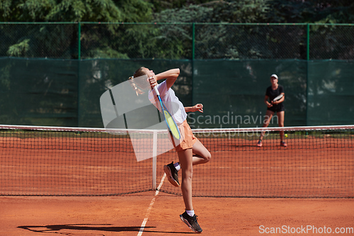 Image of Young girls in a lively tennis match on a sunny day, demonstrating their skills and enthusiasm on a modern tennis court.