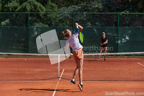 Image of Young girls in a lively tennis match on a sunny day, demonstrating their skills and enthusiasm on a modern tennis court.