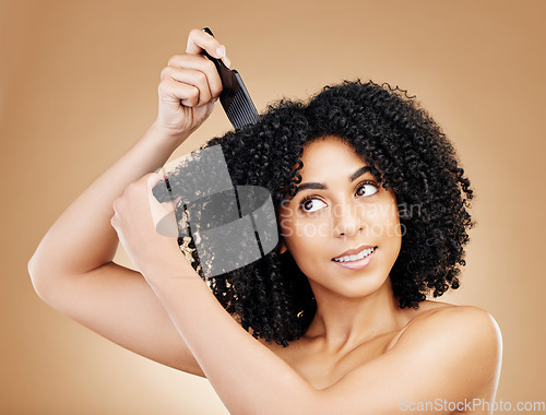 Image of Hair care, afro and woman with a comb, beauty and treatment on a brown background. Person, girl and model with salon grooming, volume or shine with glow, wellness and aesthetic with texture and clean