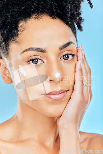 Image of Beauty skincare, portrait and woman with cream dermatology product for melasma, acne or sunscreen protection. Face makeup, studio cosmetics or person feel pimple prevention results on blue background