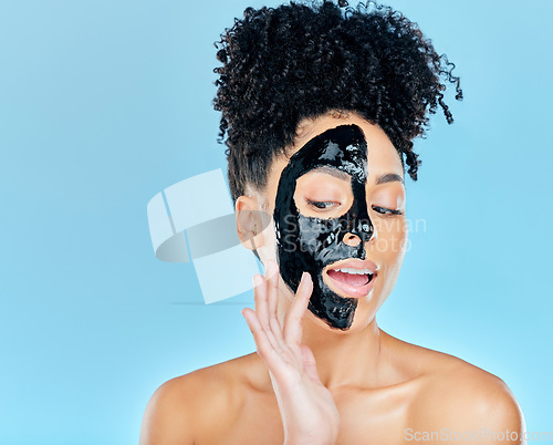 Image of Skincare, charcoal mask and woman in studio for facial treatment, anti aging detox and wellness. Beauty, salon and face of person with product for health, cosmetics or grooming on blue background