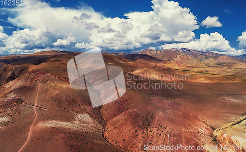 Image of Aerial shot of the textured yellow nad red mountains resembling the surface of Mars