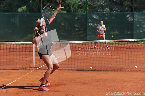 Image of Young girls in a lively tennis match on a sunny day, demonstrating their skills and enthusiasm on a modern tennis court.