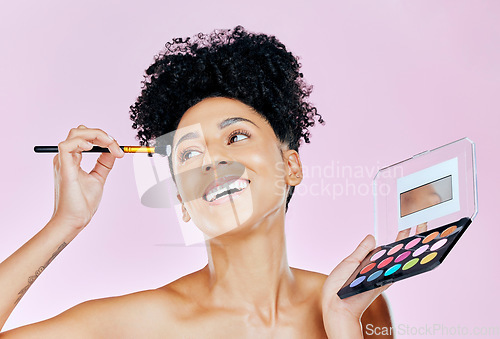 Image of Face makeup, palette and happy woman with brush, beauty routine and apply cosmetics powder, foundation or product. Happiness, skincare shine and studio person with skin treatment on pink background