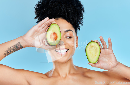 Image of Skincare, avocado and happy woman in studio for cosmetic, wellness and treatment on blue background. Beauty, fruit and female model smile with organic, dermatology or detox for glowing skin routine