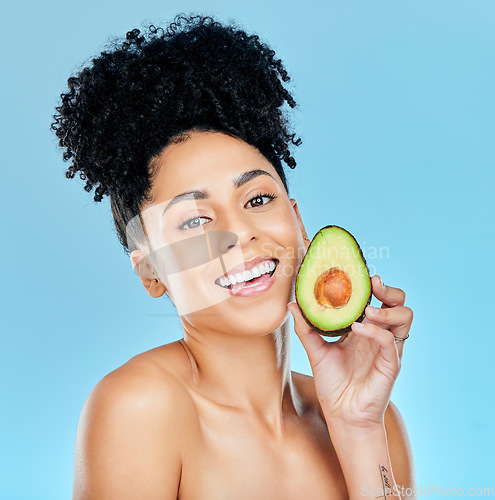 Image of Happy woman, portrait and avocado for natural skincare, beauty or diet against a blue studio background. Face of female person smile with organic vegetable for nutrition, vitamin C or skin wellness