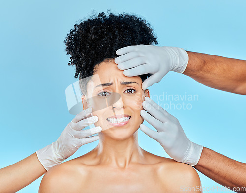 Image of Plastic surgery, portrait of scared woman with hands on face in studio for skincare consultation. Model with stress, fear and anxiety for beauty, dermatology or collagen therapy on blue background.