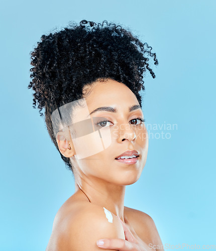 Image of Beauty, studio portrait and woman with body cream application, dermatology product or lotion for skin hydration glow. Spa salon wellness, shoulder creme and aesthetic model shine on blue background