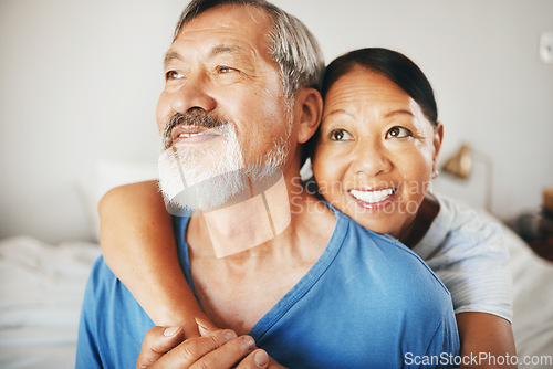 Image of Love, smile and senior couple hugging in the bedroom for bonding, thinking and relaxing together. Happy, care and elderly Asian man and woman in retirement embracing for connection by modern home.