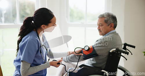 Image of Blood pressure, nurse and senior man in wheelchair for medical care, wellness and service. Healthcare, retirement home and caregiver with heart rate machine on person with disability for cardiology