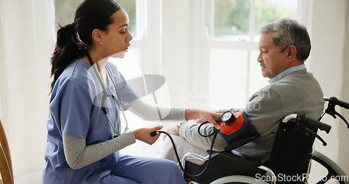 Image of Blood pressure, nurse and old man in wheelchair in house for medical care, wellness or service. Healthcare, retirement home and caregiver with heart rate machine on person with disability for support