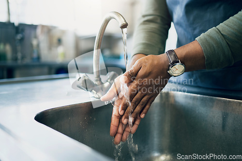 Image of Water, hygiene and washing hands in the kitchen with a person by the sink for health or wellness. Cleaning, safety and bacteria with an adult closeup in the home to rinse for skin protection
