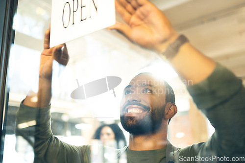 Image of Happy man, small business and open sign on door or window in ready for service or welcome at cafe. Male person, barista or waiter smile with entrance at coffee shop, restaurant or cafeteria store