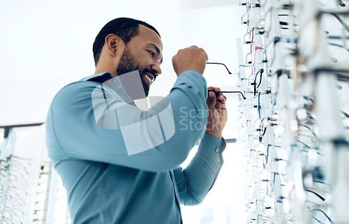 Image of Optometry, vision and happy man with glasses for decision, choice and eye care option in optician store. Healthcare, ophthalmology and person in clinic for prescription lens, spectacles and frames