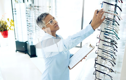 Image of Stock, optometrist or senior woman with glasses checklist in store for retail inventory or eyewear choice. Vision, product or optician in clinic writing on clipboard for eye care in optometry shop