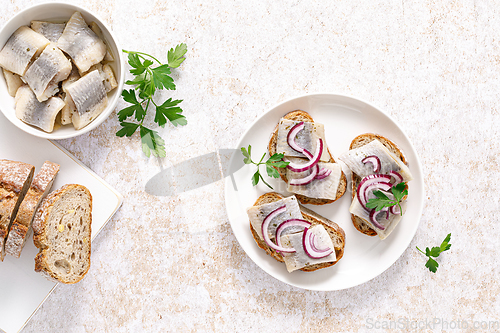 Image of Herring sandwich. Toast with bread, herring and onion. Top view