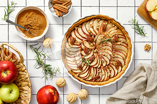 Image of Apple pie. Apple tart with cinnamon, walnuts and pecan nuts, top view