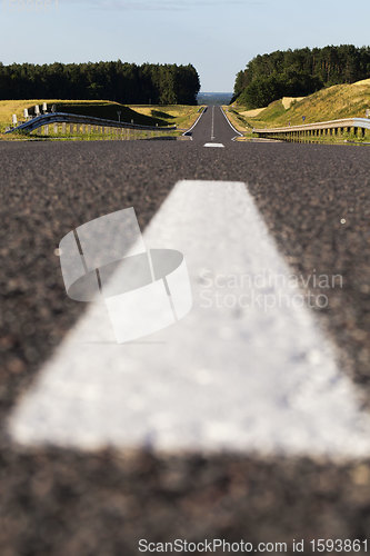 Image of close-up of an asphalt road with white road markings