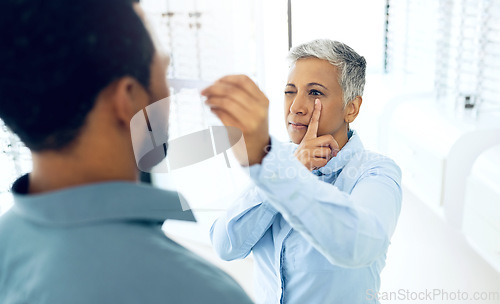 Image of Vision, eyes and medical test with a man at the optometrist for prescription diagnosis or assessment. Distance, measure or exam with a customer talking to a consultant at the optician for assistanc