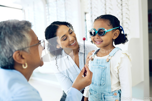 Image of Optometry, eye test and optometrist with child and mother at an ophthalmology appointment. Medical, wellness and senior optician with young mom and girl kid patient with lenses in an optical clinic.