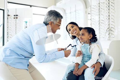 Image of Optometrist, kid and glasses for eye care, vision or consultation in medical office for lens. Woman, girl and family for support, trust and wellness for appointment, optometry or treatment for health