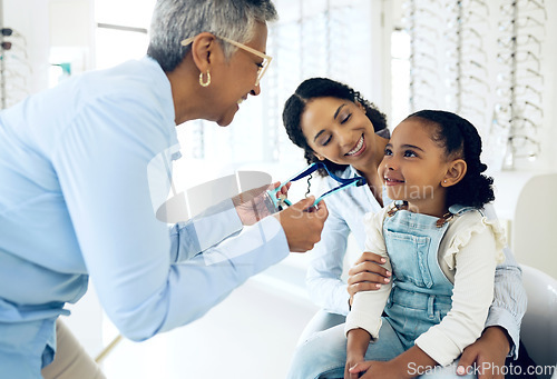 Image of Optical, glasses and optometrist with child and mother at an eye care appointment for test. Health, wellness and senior optician with young mom and girl kid patient with lenses in an optometry clinic