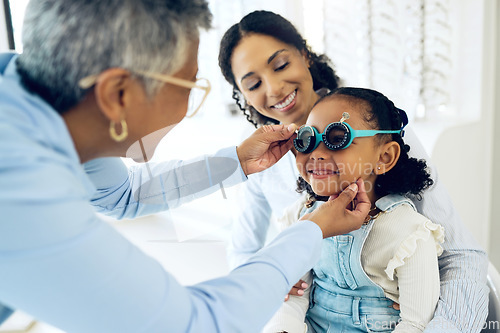 Image of Trial lens, optical and optometrist with child and mother at an eye care appointment for test. Health, wellness and senior optician with young mom and girl kid patient with tool in optometry clinic.