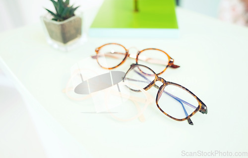 Image of Glasses, vision and choice, optometry and frame with prescription lens on table, display and eye care. Designer, fashion and eyewear, health and product closeup, service and ophthalmology background