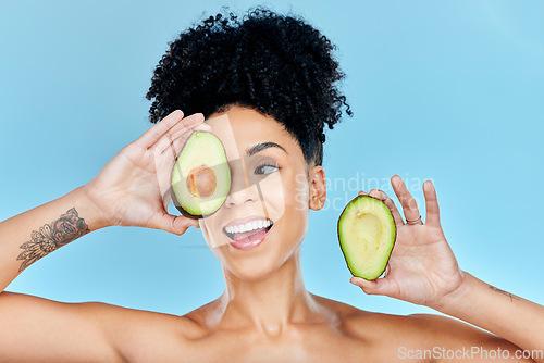 Image of Happy woman, face and avocado for natural skincare, beauty or diet against a blue studio background. Female person or model smile with organic vegetable for nutrition, vitamin C or skin wellness