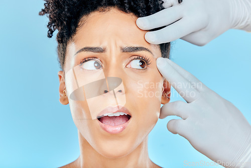 Image of Beauty, plastic surgery and scared woman with hands on face in studio for cosmetic facial consultation. Skincare, dermatology and professional collagen therapy, model on blue background with fear.