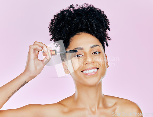 Image of Portrait, smile and mascara with a woman on a pink background in studio to apply makeup or cosmetics. Beauty, skincare and face product with a happy young model on color for eyelash cosmetology