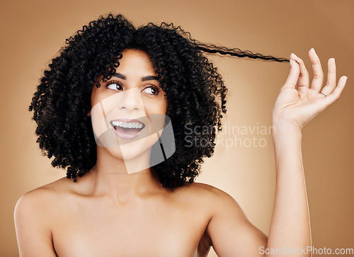 Image of Curly hair, strand and woman in studio for beauty, healthy growth or natural coil textures on brown background. Happy model pull afro hairstyle for salon aesthetic, keratin treatment or cosmetic care