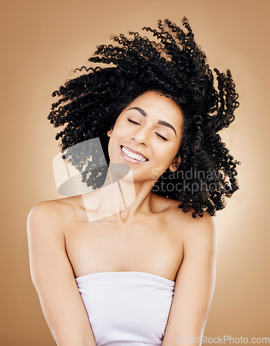 Image of Hair, shake curls and wind, woman with beauty and treatment for shine, cosmetic care and smile on studio background. Wellness, haircare and growth with strong texture and curly locks, volume and afro