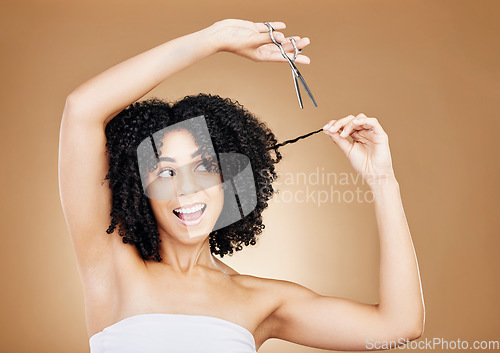 Image of Cutting, hair care and woman with scissors, smile and excited on a brown studio background. Person, happy girl and model with afro, curly and wow with growth, mockup space and grooming with aesthetic