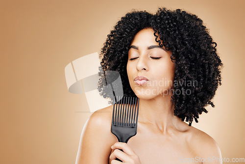 Image of Hair care, comb and curly woman in a studio with young, natural and salon treatment. Health, beauty and female model from Mexico with cosmetic tool for healthy hairstyle isolated by brown background.