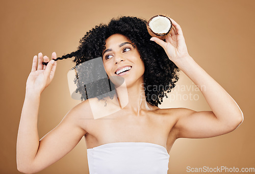 Image of Hair, growth and coconut with woman and beauty, natural cosmetics and skin isolated on studio background. Health, oil or cream product with fruit, eco friendly for texture and shine with haircare