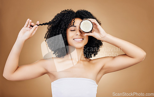 Image of Woman, hair and coconut with shine and beauty, organic salon treatment for strong texture on studio background. Face, skin and natural cosmetic product for growth, haircare and fruit with smile